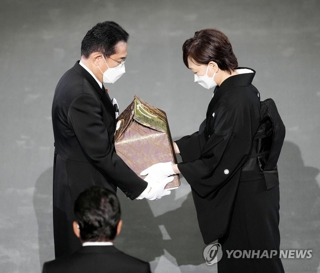 (도쿄 교도=연합뉴스) 아베 신조 전 일본 총리 국장(國葬)이 27일 오후 2시 도쿄 소재 일본무도관에서 열렸다. 아베 전 총리 미망인인아키에 여사(오른쪽)가 유골을 기시다 후미오 총리(왼쪽)에게 전달하고 있다. 2022.09.27 