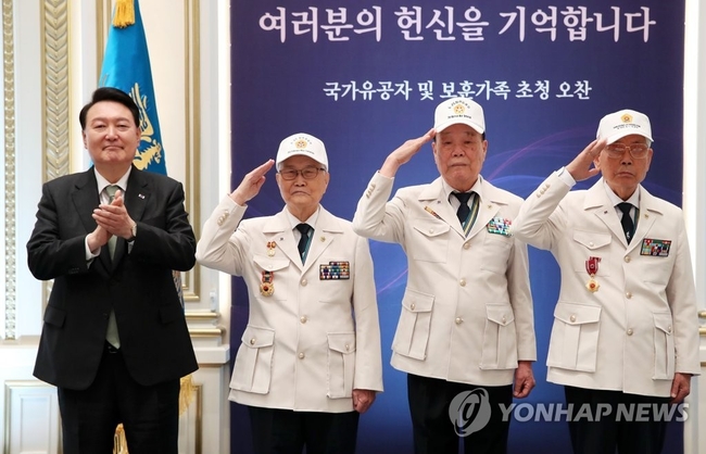  윤석열 대통령이 14일 청와대 영빈관에서 열린 국가유공자 및 보훈가족 초청 오찬에서 대한민국6.25참전유공자회 손희원 회장<br>
(왼쪽 두번째부터), 김창석. 이하영 이사에게 '영웅의 제복'을 직접 입혀준 뒤 기념촬영을 하고 있다. 2023.6.14<br>
【대통령실통신사진기자단=연합뉴스】