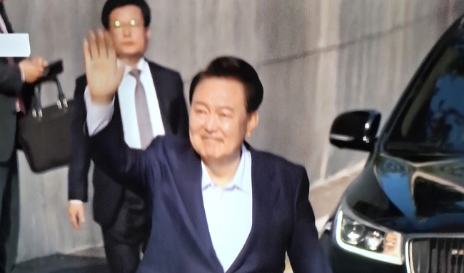 윤석열 전 대통령이 11일 사저를 떠나면서 지지자들에게 손을 흔드는 모습